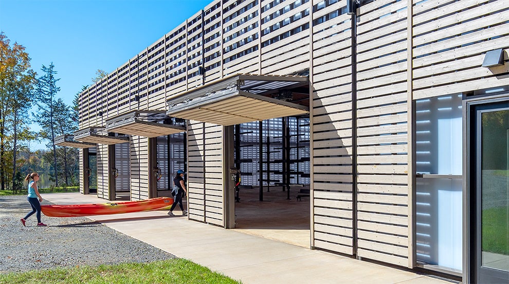 Four Schweiss bifold doors cladded in wood installed on Beaverdam Crew Facility shown open Four Schweiss bifold doors cladded in wood installed on Beaverdam Crew Facility shown open