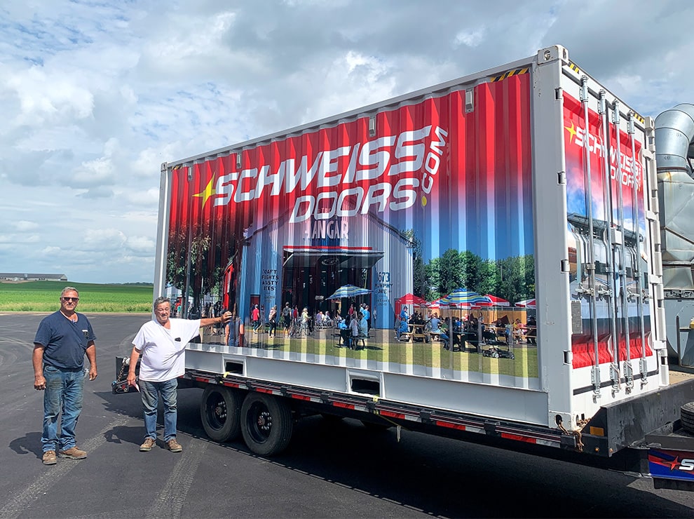 Mike and Dave Schweiss posing beside Schweiss container fitted with Schweiss Doors