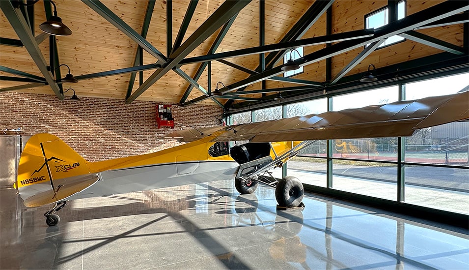 Side view of Don Smith Jr's plane parked inside his backyard hangar fitted with Schweiss glass hydraulic door shown closed Side view of Don Smith Jr's plane parked inside his backyard hangar fitted with Schweiss glass hydraulic door shown closed
