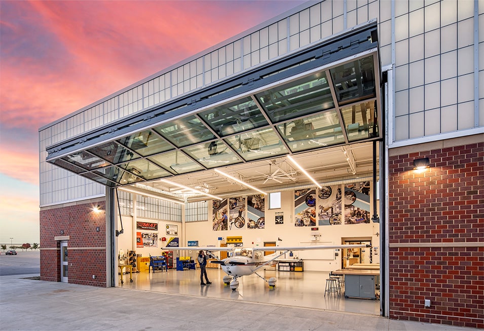 Exterior view from right of Schweiss glass bifold door installed on Lincoln North Star High School whown open Exterior view from right of Schweiss glass bifold door installed on Lincoln North Star High School whown open