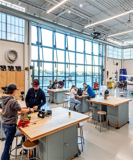 Interior view of Schweiss glass bifold door installed on Lincoln North Star High School behind group of students Interior view of Schweiss glass bifold door installed on Lincoln North Star High School behind group of students