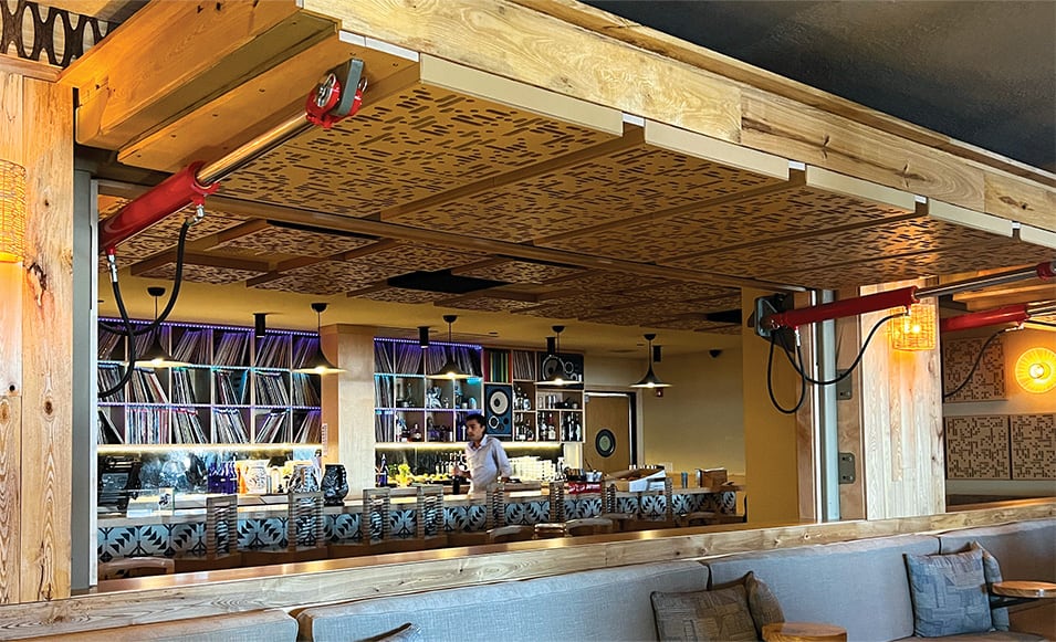 Two opened Schweiss hydraulic doors used as a separator in Macanda Mexican Restaurant viewed at angle from the front