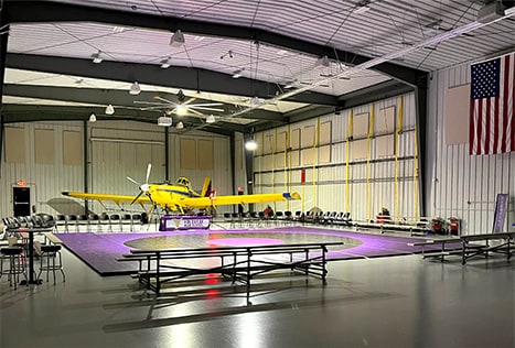 Interior view from left of Dusters logo on the ground inside Nebraskaland Hangar, one plane parked inside Interior view from left of Dusters logo on the ground inside Nebraskaland Hangar, one plane parked inside