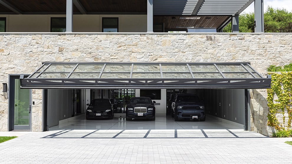 Schweiss hydraulic glass door installed on luxurious attached garage in Boston Schweiss hydraulic glass door installed on luxurious attached garage in Boston