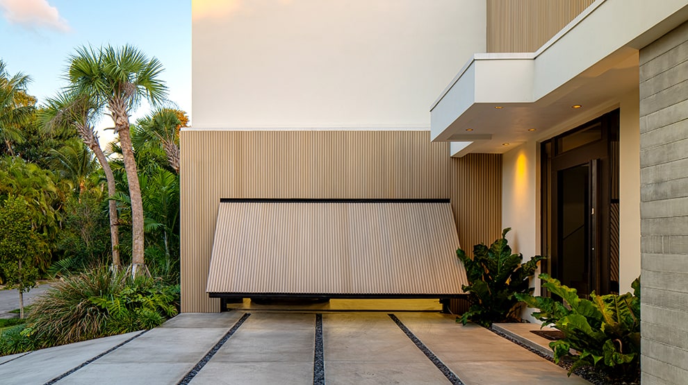 Garage of luxury home in Miami, Florida that is fitted with a Schweiss custom hydraulic garage door shown opening Garage of luxury home in Miami, Florida that is fitted with a Schweiss custom hydraulic garage door shown opening