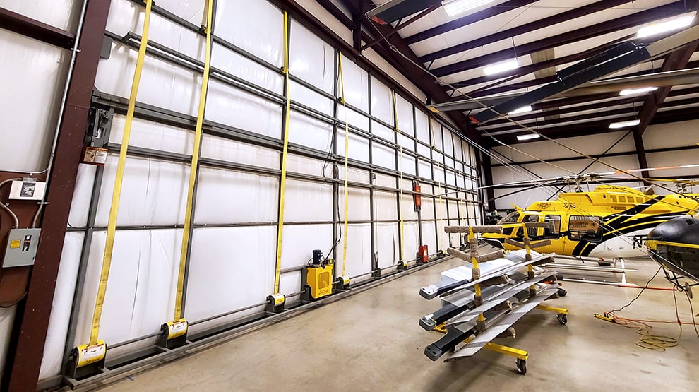 Interior view of Helicopter Express hangar fitted with a Schweiss lift strap bifold door shown closed Interior view of Helicopter Express hangar fitted with a Schweiss lift strap bifold door shown closed