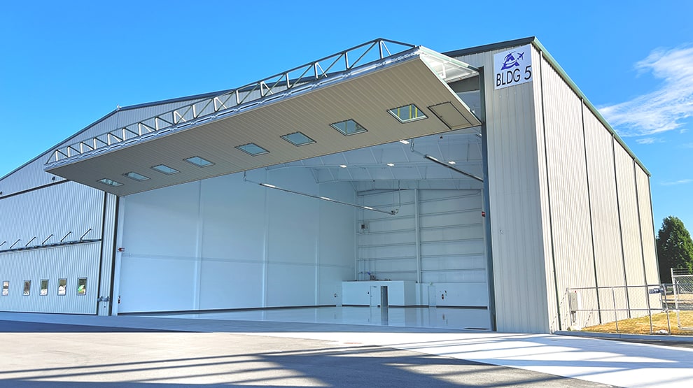 Schweiss lift strap bifold door installed on hangar at Skagit Regional Airport shown open Schweiss lift strap bifold door installed on hangar at Skagit Regional Airport shown open