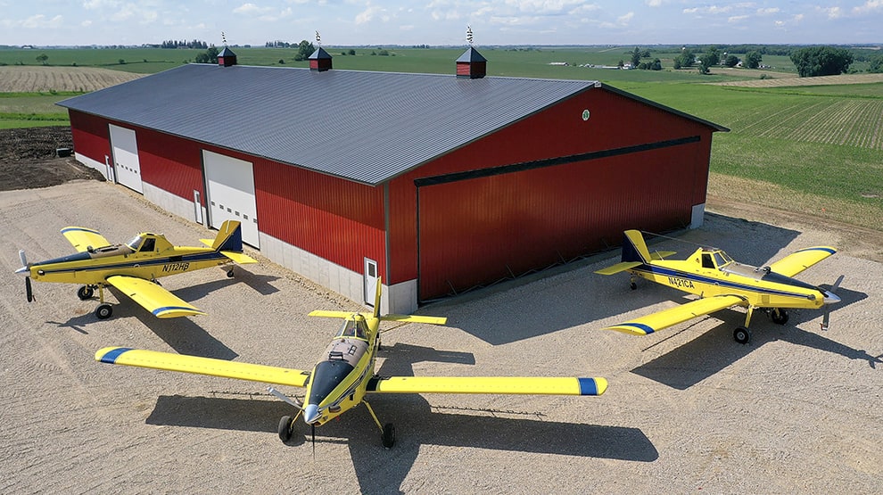 Three planes parked outside of agricultural building that is fitted with a Schweiss hydraulic door Three planes parked outside of agricultural building that is fitted with a Schweiss hydraulic door