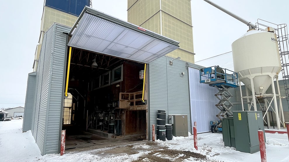 Schweiss lift strap bifold door installed on commercial business shown open during the winter Schweiss lift strap bifold door installed on commercial business shown open during the winter