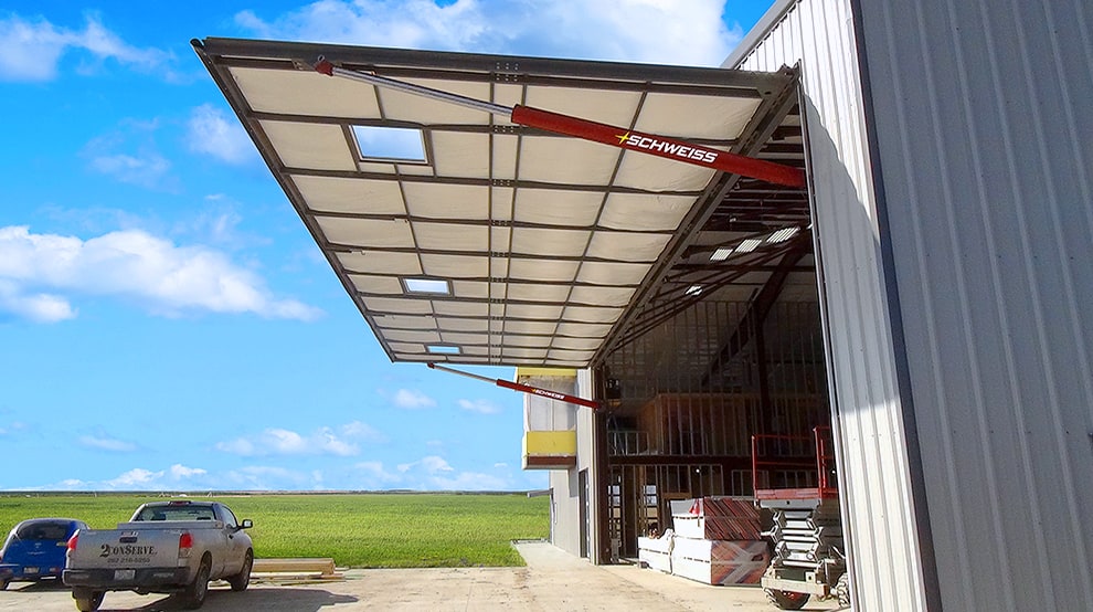 Side view from outside of Schweiss hydraulic ag building door installed on agricultural building Side view from outside of Schweiss hydraulic ag building door installed on agricultural building