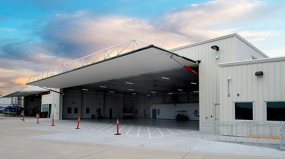 Schweiss hydraulic cylinders holding up Schweiss hydraulic hangar doors fitted on helicopter hangar Schweiss hydraulic cylinders holding up Schweiss hydraulic hangar doors fitted on helicopter hangar