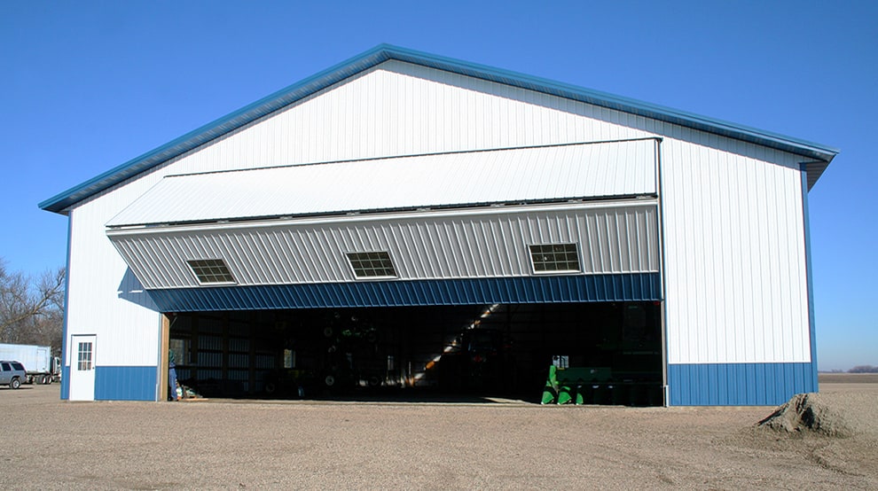 Schweiss bifold machine shed door with windows installed on farm shed shown opening Schweiss bifold machine shed door with windows installed on farm shed shown opening