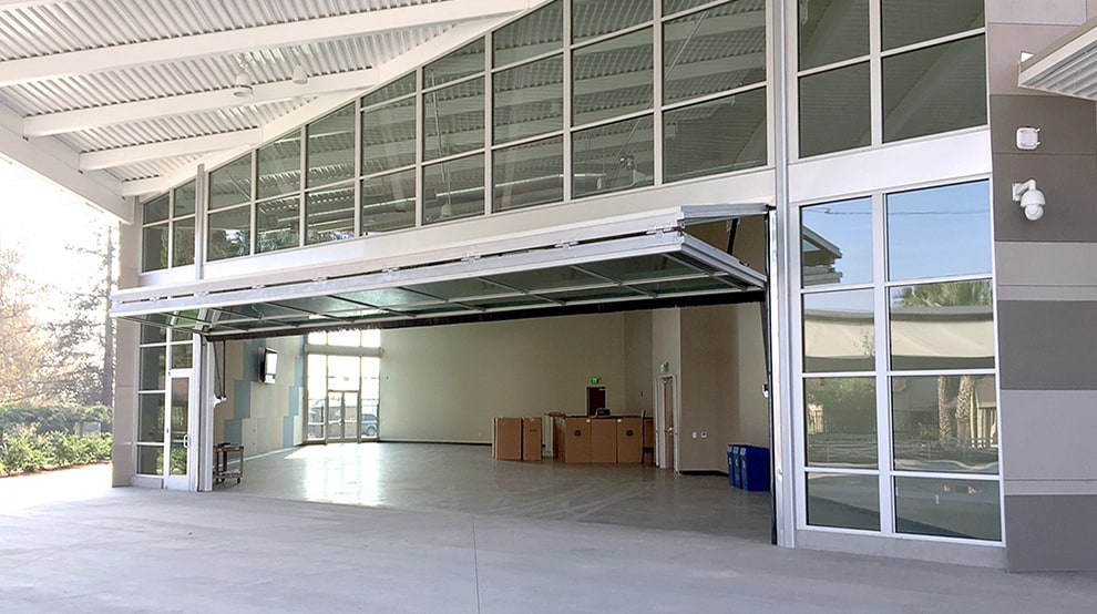 Schweiss bifold glass designer door installed on glass entrance of building Schweiss bifold glass designer door installed on glass entrance of building