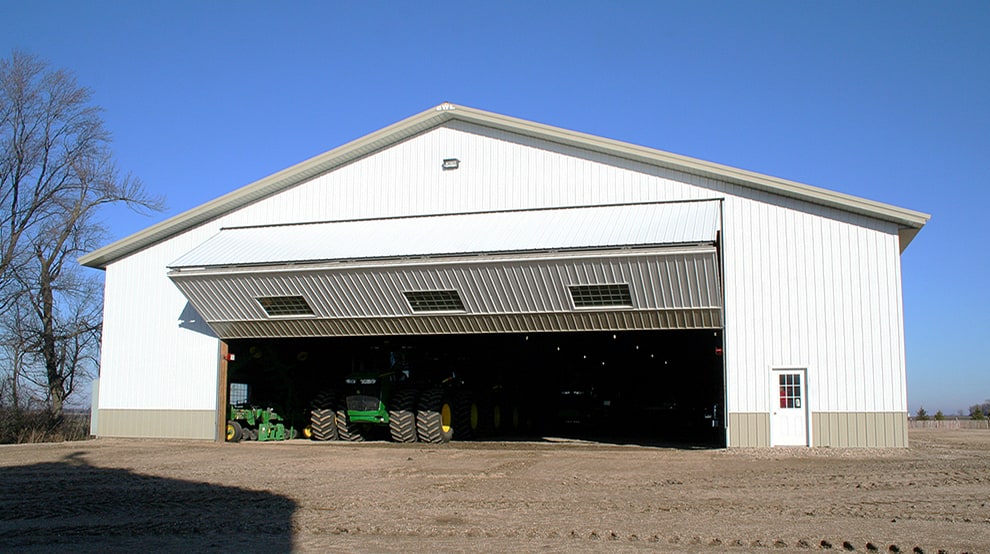 Schweiss bifold machine shed door with windows installed on an ag building shown opening Schweiss bifold machine shed door with windows installed on an ag building shown opening