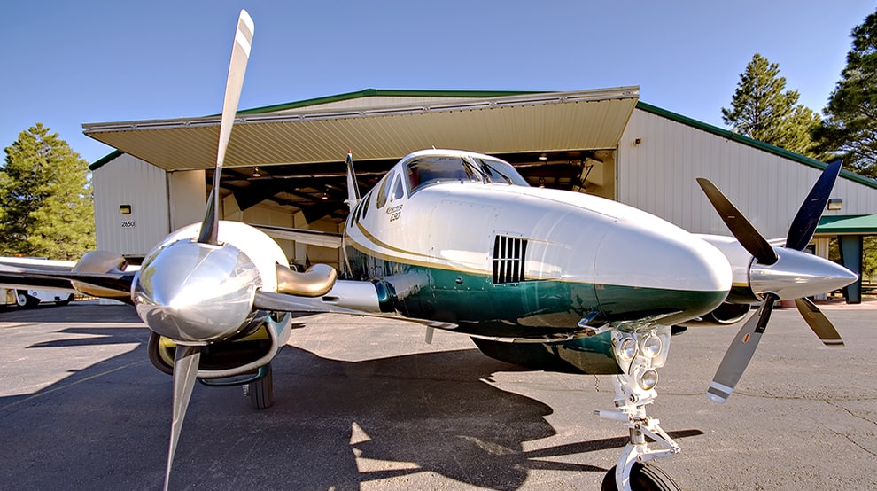 Closeup of plane parked outside of hangar fitted with a Schweiss bifold door shown fully open Closeup of plane parked outside of hangar fitted with a Schweiss bifold door shown fully open