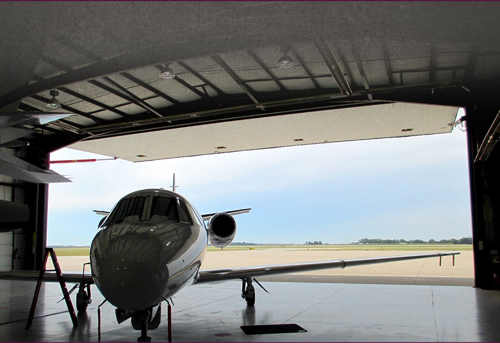 Plane parked inside hangar fitted with Arkansas hydraulic door by Schweiss