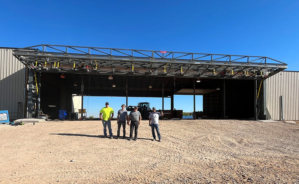 Group posed in front of installed Missouri stand-alone bifold frame